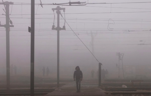 a man crosses railway tracks amidst heavy fog on a cold winter morning in new delhi india january 9 2023 photo reuters anushree fadnavis