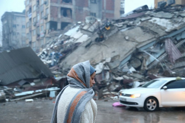 a woman stands near a collapsed building after an earthquake in kahramanmaras turkey february 6 2023 photo reuters a woman stands near a collapsed building after an earthquake in kahramanmaras turkey february 6 2023 photo reuters