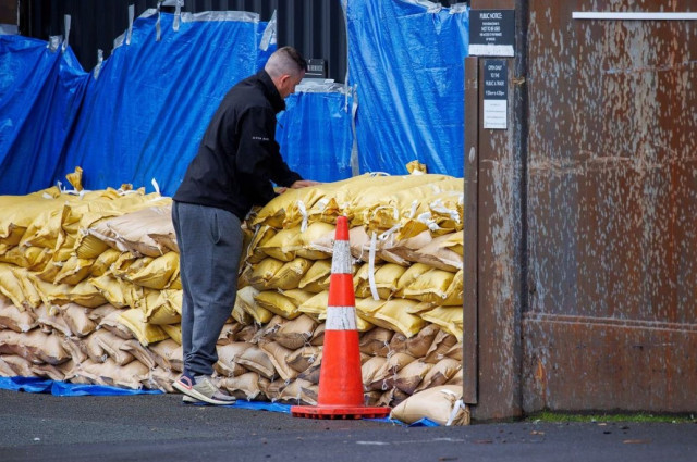 a man stacks up sandbags to protect a warehouse before the arrival of cyclone gabriele in auckland new zealand february 12 2023 photo reuters