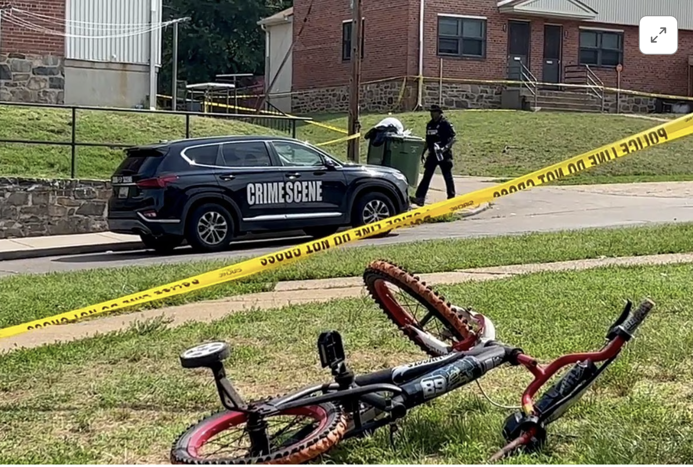 a police officer passes a child s bicycle after a mass shooting at the scene of a fourth of july holiday weekend block party in baltimore maryland us july 2 2023 in a still image from video photo reuters