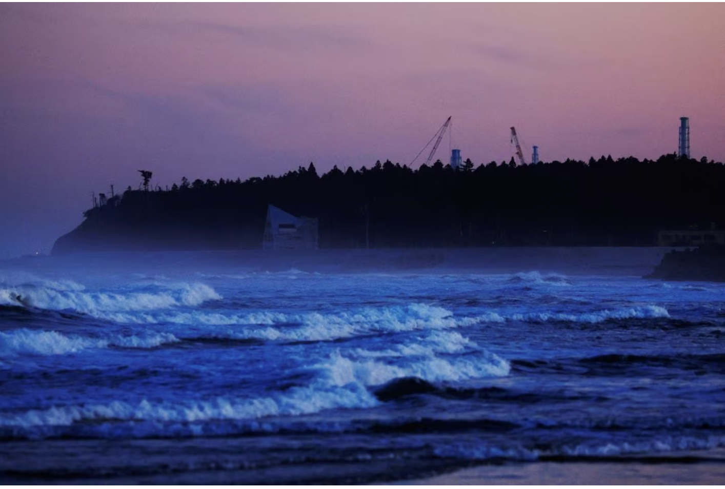 ventilation stacks and cranes at the disabled fukushima dai ichi nuclear power plant are seen from a beach in namie about 7 km away from the power plant in fukushima prefecture japan february 28 2023 reuters file