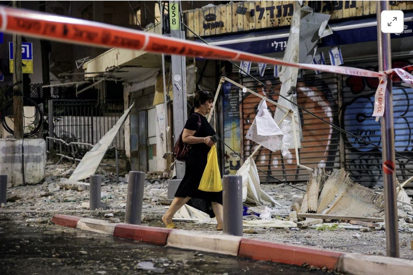 A woman walks past the site where a rocket launched from the Gaza Strip landed in Tel Aviv, Israel October 7, 2023. PHOTO: REUTERS