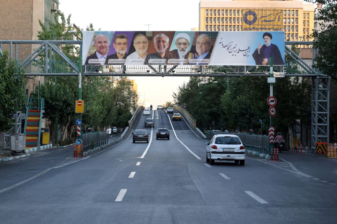 a billboard with a picture of the late president ebrahim raisi and the presidential candidates is displayed on a street in tehran iran june 17 2024 majid asgaripour wana west asia news agency via reuters