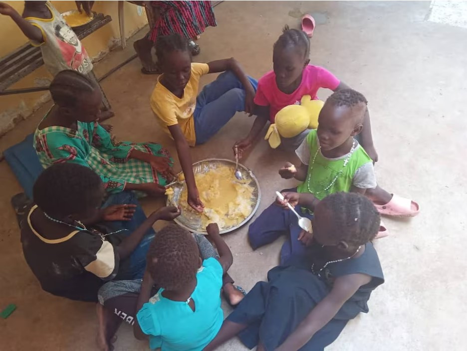 refugees eat food at dar mariam a catholic church and school compound in al shajara district where they took shelter in khartoum sudan photo reuters