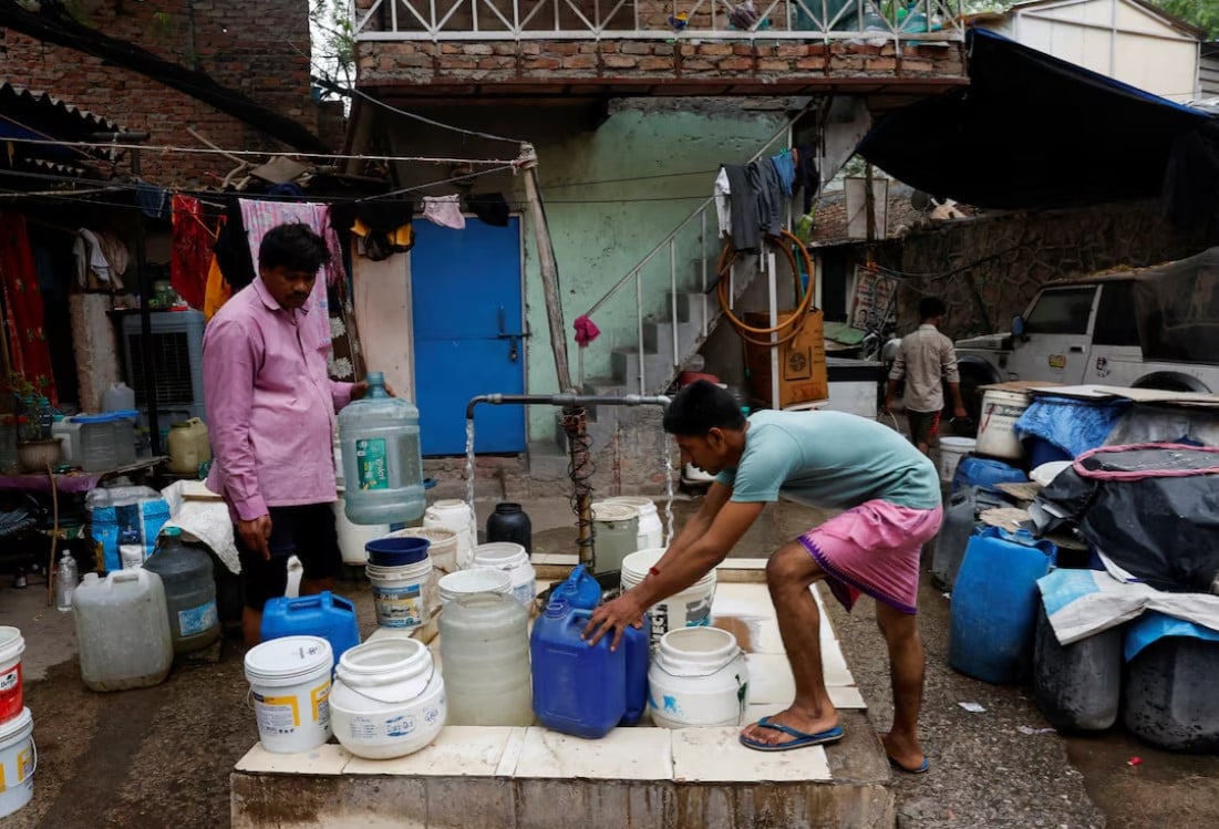 residents fill their containers from a tap that dispenses water twice a day at a slum in new delhi india photo reuters