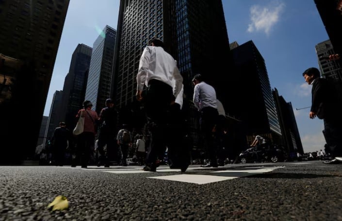 people walk on a crosswalk at a business district in central tokyo japan photo reuters