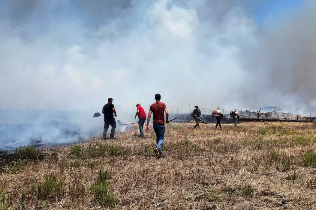 people work to put out fires after hezbollah launched projectiles at israel amid hostilities between hezbollah and israeli forces in the galilee northern israel photo reuters