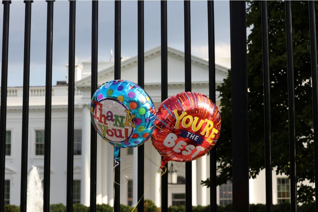 balloons that were tied to the fence are pictured as people gather outside the white house after u s president joe biden announced he is stopping his bid for reelection in washington d c us photo reuters