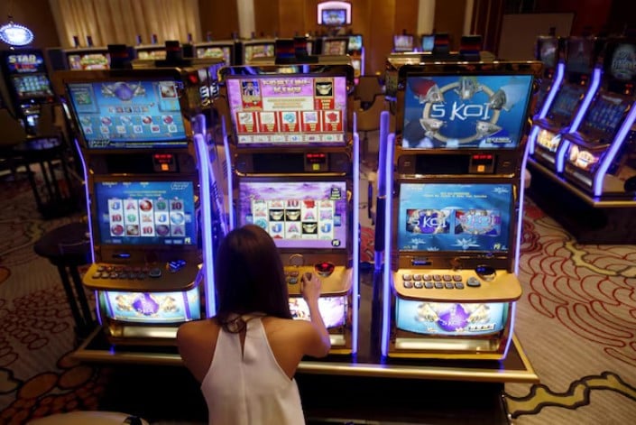 a casino trainee demonstrates how to play a slot machine in the philippines photo reuters