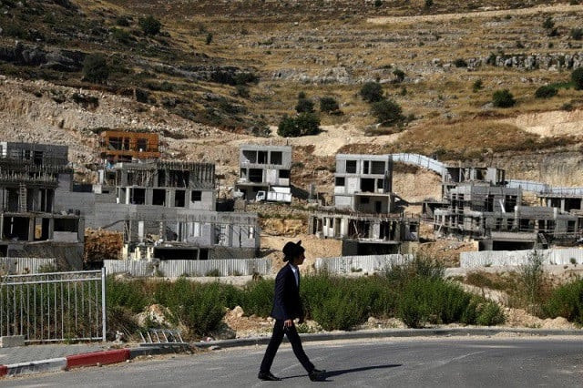a jewish settler walks past israeli settlement construction sites around givat zeev and ramat givat zeev in the israeli occupied west bank near jerusalem june 30 2020 photo reuters a jewish settler walks past israeli settlement construction sites around givat zeev and ramat givat zeev in the israeli occupied west bank near jerusalem june 30 2020 photo reuters