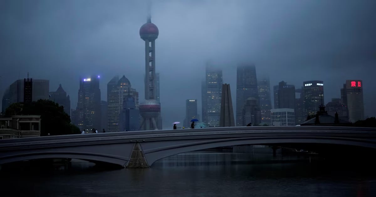 people walk with umbrellas on a bridge amid rains and winds in shanghai china on september 14 2022 photo reuters