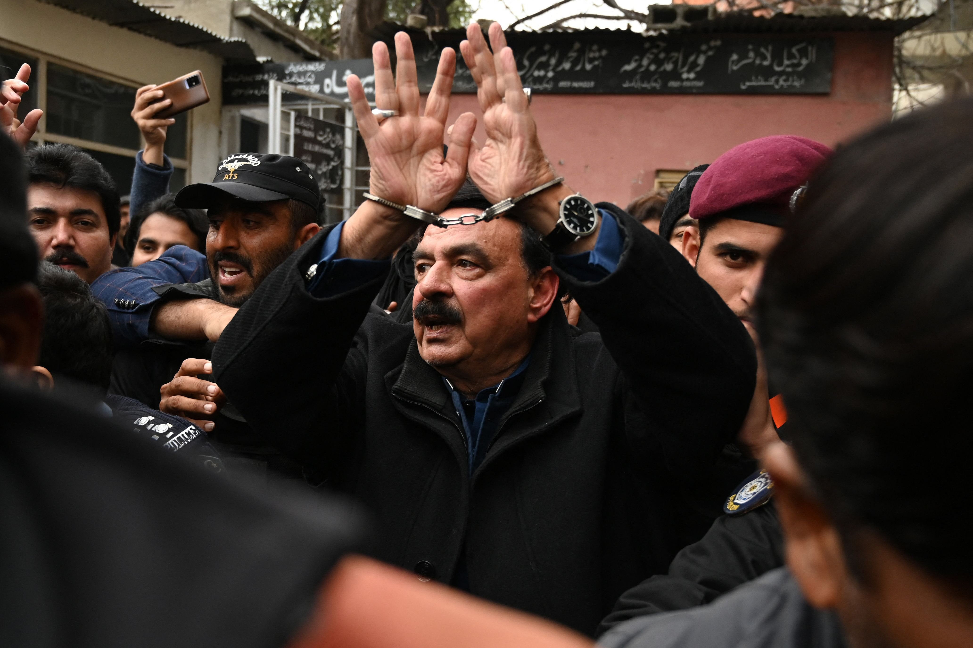 police officials escort former interior minister sheikh rashid ahmed to present him before a court in islamabad photo inp
