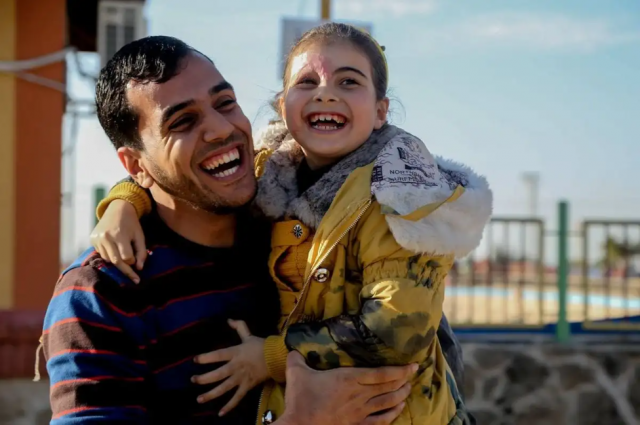palestinian journalist yaser murtaja with beesan a palestinian child who lost most of her family after israeli forces bombed her home photo publicity