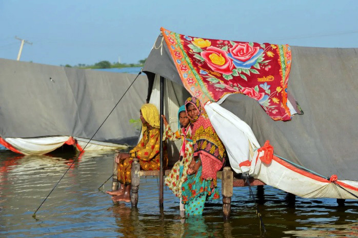 a flood victim family take refuge with their belongings as floodwater rises following rains and floods during the monsoon season in sohbatpur photo reuters