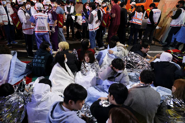 people sit on the street after being rescued at the scene where dozens of people were injured in a stampede during a halloween festival in seoul south korea october 29 2022 photo reuters people sit on the street after being rescued at the scene where dozens of people were injured in a stampede during a halloween festival in seoul south korea october 29 2022 photo reuters