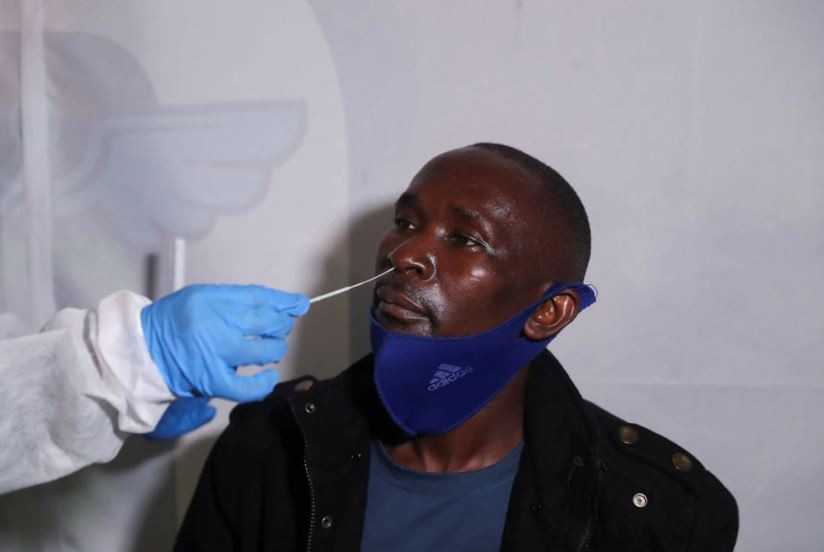 a healthcare worker collects a swab from a passenger for a pcr test against the coronavirus disease covid 19 before traveling to uganda amidst the spread of the new sars cov 2 variant omicron at o r tambo international airport in johannesburg south africa november 28 2021 photo reuters