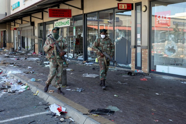 members of the military patrol past looted shops as the country deploys army to quell unrest linked to jailing of former president jacob zuma in soweto south africa july 13 2021 photo reuters members of the military patrol past looted shops as the country deploys army to quell unrest linked to jailing of former president jacob zuma in soweto south africa july 13 2021 photo reuters