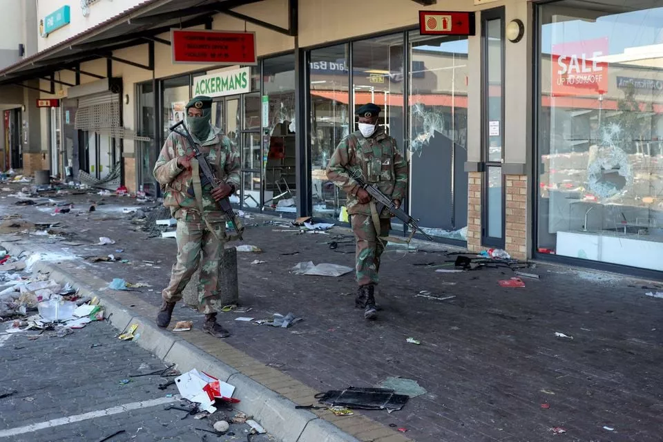 members of the military patrol past looted shops as the country deploys army to quell unrest linked to jailing of former president jacob zuma in soweto south africa july 13 2021 photo reuters members of the military patrol past looted shops as the country deploys army to quell unrest linked to jailing of former president jacob zuma in soweto south africa july 13 2021 photo reuters