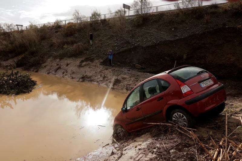 people stand in a flooded area after heavy rains and floods in alora spain october 29 2024 reuters spanish floods kill 64 as year of rain falls in a day in valencia photo reuters