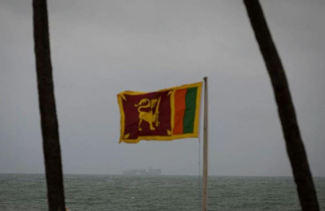a cargo ship sails towards colombo harbour as a sri lankan national flag is seen amid the country s economic crisis in colombo sri lanka july 23 2022 photo reuters a cargo ship sails towards colombo harbour as a sri lankan national flag is seen amid the country s economic crisis in colombo sri lanka july 23 2022 photo reuters