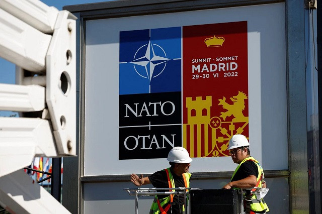 workers paste the posters announcing the nato summit outside the madrid fair before a nato summit in madrid spain june 27 2022 photo reuters