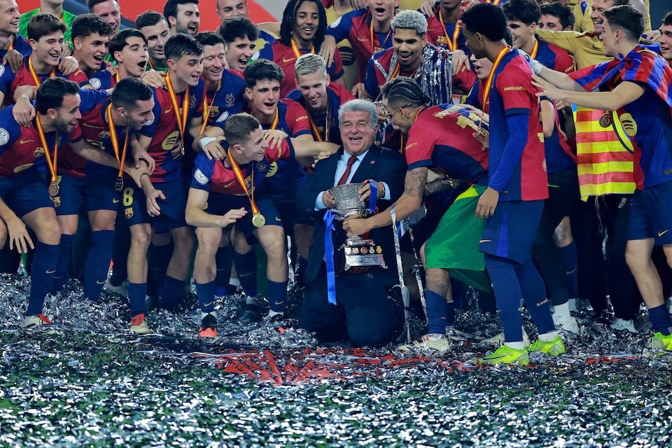 fc barcelona president joan laporta celebrates with the trophy and players after winning the spanish super cup against real madrid at king abdullah sports city jeddah saudi arabia on sunday photo afp