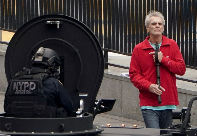 a man holds a gun under his chin as he speaks with members of the nypd outside the united nations headquarters in new york city u s december 2 2021 photo reuters