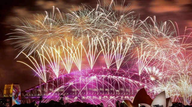 fireworks light up the sky above the sydney harbour bridge and opera house as new year s eve celebrations begin around the world photo afp
