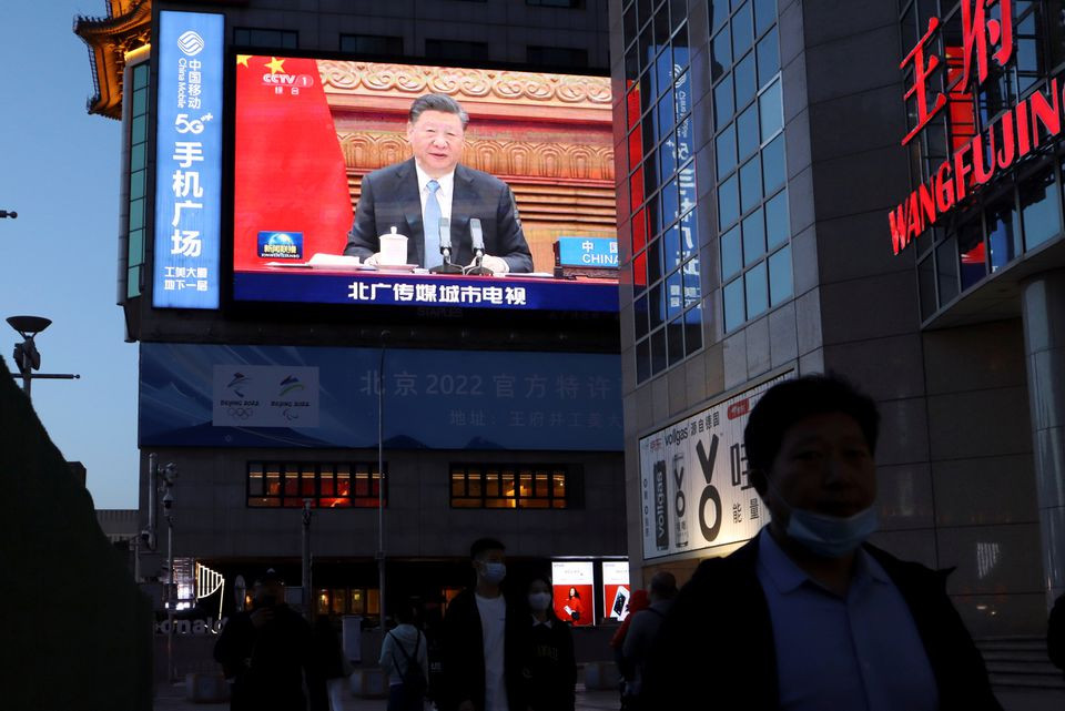 a giant screen shows news footage of chinese president xi jinping attending a video summit on climate change with german chancellor angela merkel and french president emmanuel macron at a shopping street in beijing china april 16 2021 photo reuters