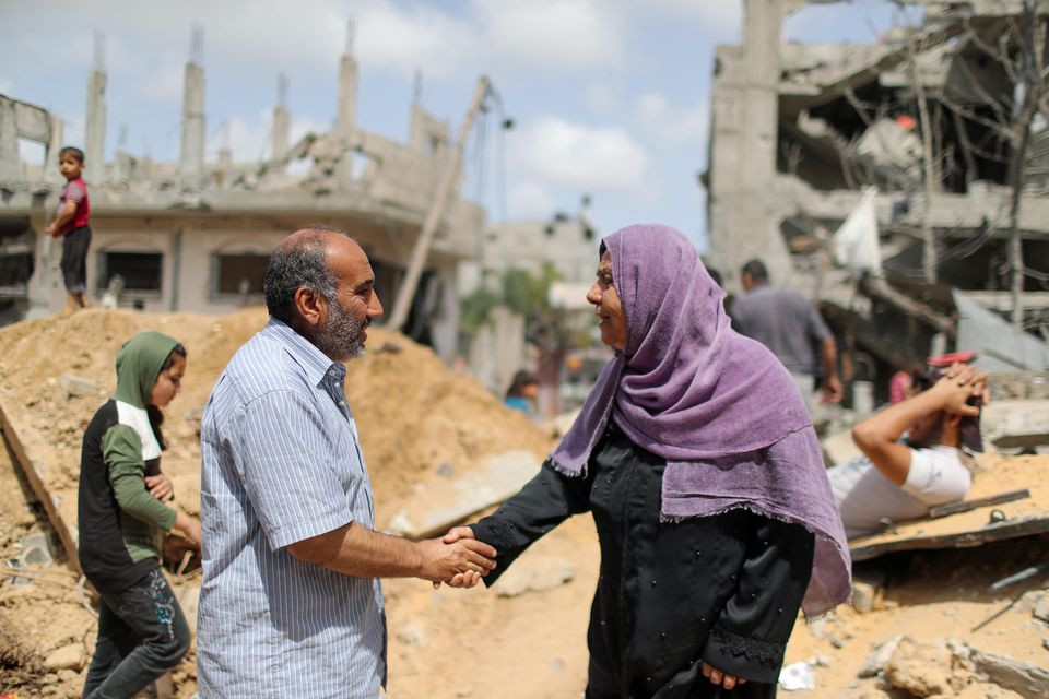 palestinians shake hands after returning to their destroyed houses following israel  hamas truce in beit hanoun in the northern gaza strip may 21 2021 photo reuters