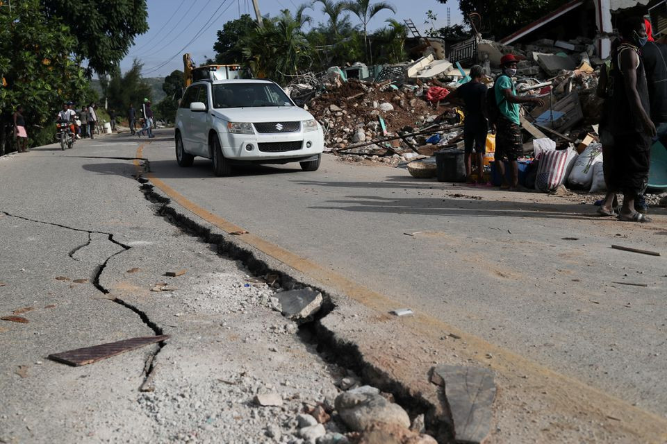 a car drives past a damaged road after the earthquake that took place on august 14th in marceline near les cayes haiti august 20 2021 photo reuters