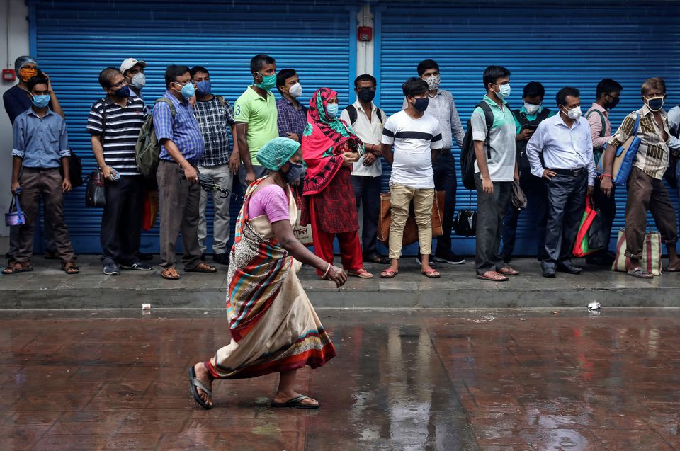 passengers wearing masks wait in a queue to board a bus after authorities eased lockdown restrictions that were imposed to slow the spread of the coronavirus disease covid 19 in kolkata india photo reuters