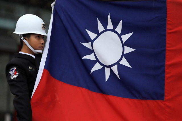 a military honour guard holds a taiwanese national flag as he attending flag raising ceremony at chiang kai shek memorial hall in taipei taiwan march 16 2018 photo reuters