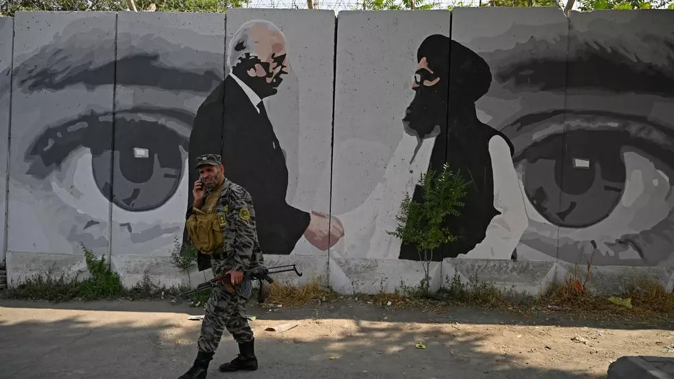 a soldier walks past a mural with images of us special representative for afghanistan reconciliation zalmay khalilzad left and taliban co founder mullah abdul ghani baradar photo afp