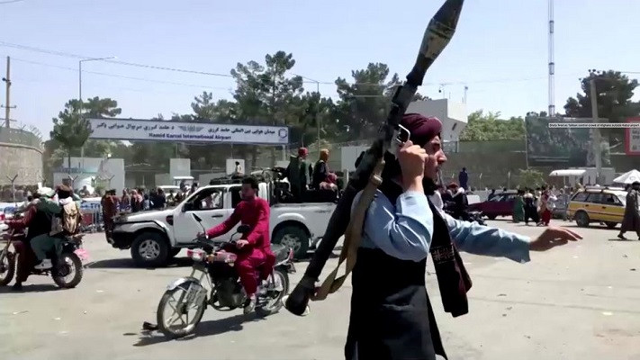 a taliban fighter runs towards crowd outside kabul airport kabul afghanistan august 16 2021 in this still image taken from a video photo reuters