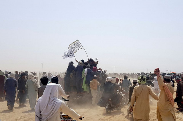 people standing on a vehicle hold taliban flags as people gather near the friendship gate crossing point in the pakistan afghanistan border town of chaman photo reuters people standing on a vehicle hold taliban flags as people gather near the friendship gate crossing point in the pakistan afghanistan border town of chaman photo reuters