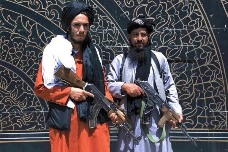 taliban fighters stand guard in front of the provincial governor s office in herat where the insurgents issued amnesty letters to afghan soldiers photo afp