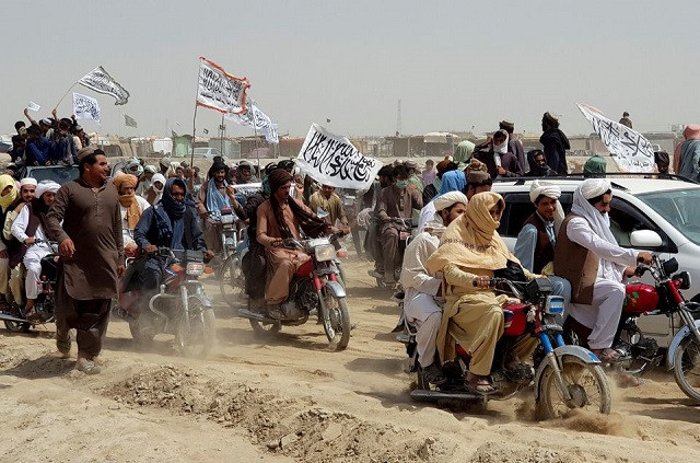 people on vehicles holding taliban flags gather near the friendship gate crossing point in the pakistan afghanistan border town of chaman pakistan july 14 2021 photo reuters