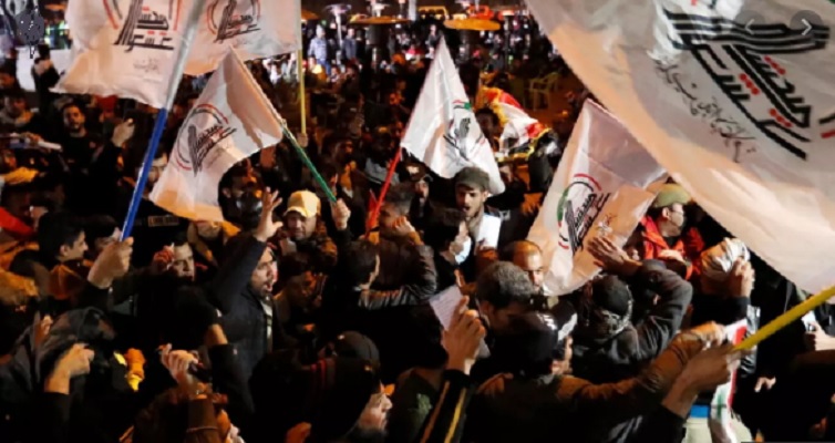 people wave flags during the first anniversary of the killing of senior iranian military commander general qassem soleimani and iraqi militia commander abu mahdi al muhandis in a us attack in baghdad iraq january 2 2021 photo reuters