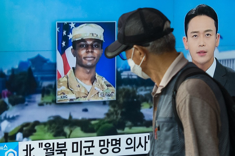 a man walks past a television showing a news broadcast featuring a photo of us soldier travis king seoul august 16 2023 photo afp