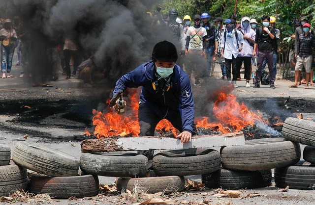 a man stands behind a barricade during a protest against the military coup in yangon myanmar march 27 2021 photo reuters