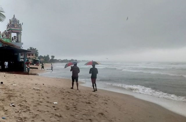 two men walk along a beach as cyclone burevi is expected to hit near the coast of trincomalee sri lanka december 2 2020 photo reuters