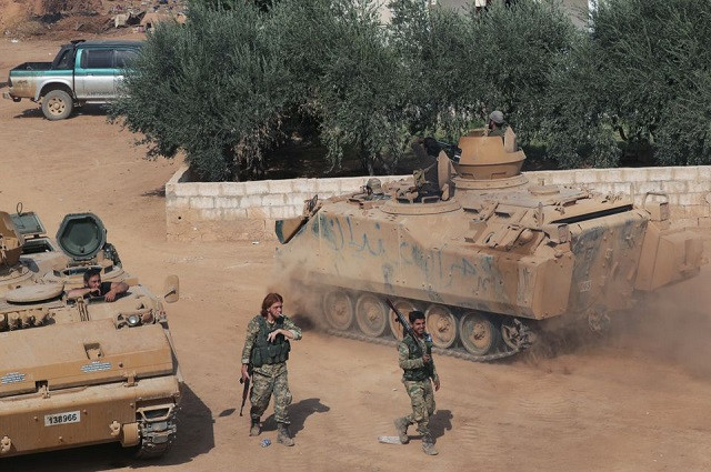 turkey backed syrian rebel fighters walk past military tanks as they gather near the border town of tal abyad syria october 24 2019 photo reuters