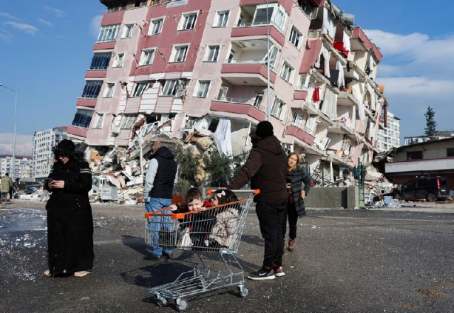 children sit in a shopping cart near a collapsed building following an earthquake in hatay turkey february 7 2023 photo reuters children sit in a shopping cart near a collapsed building following an earthquake in hatay turkey february 7 2023 photo reuters