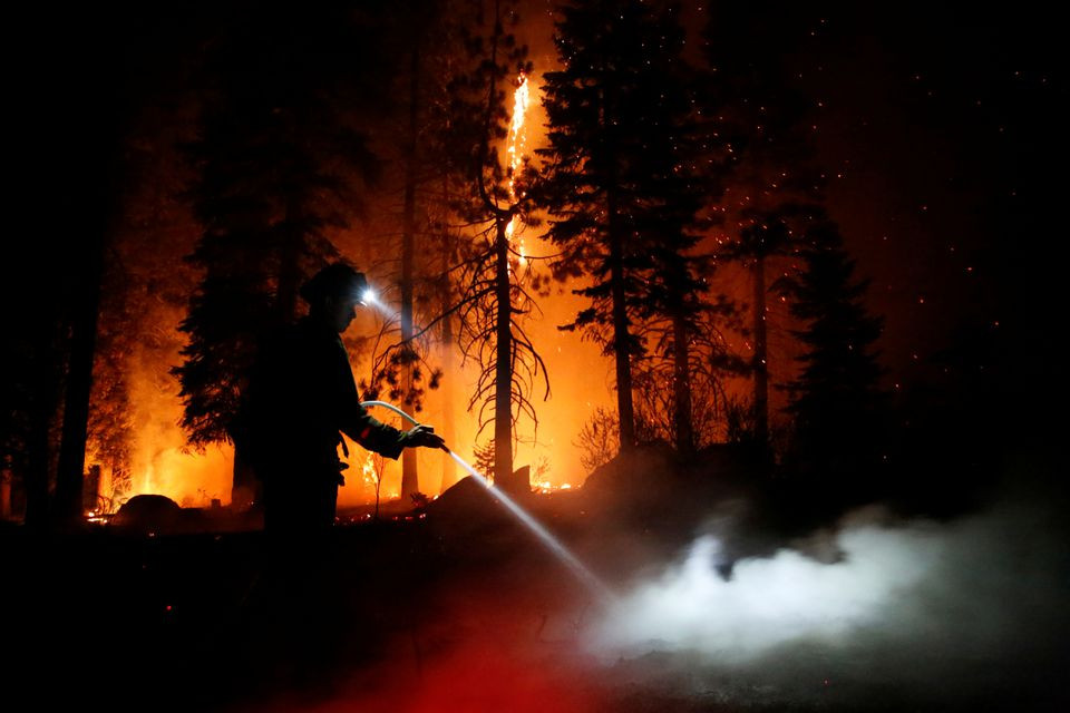 patrick r 27 a firefighter with cal fire sprays water on hot spots as flames from the caldor fire burn through trees in christmas valley near south lake tahoe california u s august 31 2021 photo reuters