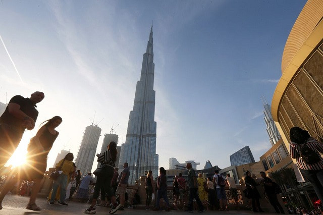 people are seen in front of burj khalifa the world tallest building in dubai united arab emirates march 12 2020 photo reuters