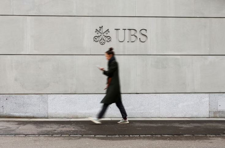 a person walks in front of a logo of the swiss bank ubs in zurich switzerland march 20 2023 photo reuters