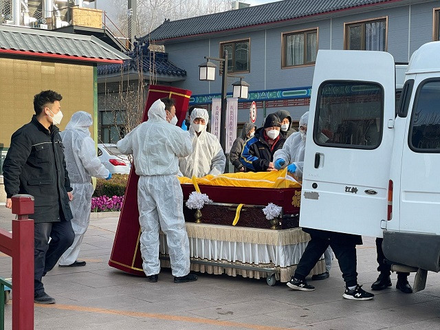 workers in protective suits transfer a body in a casket at a funeral home amid the coronavirus disease covid 19 outbreak in beijing china december 17 2022 photo reuters
