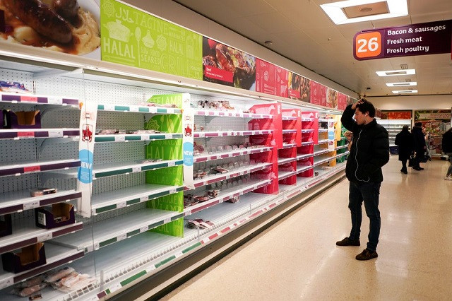 a man stands next to shelves empty of fresh meat in a supermarket as the number of worldwide coronavirus cases continues to grow in london britain march 15 2020 photo reuters