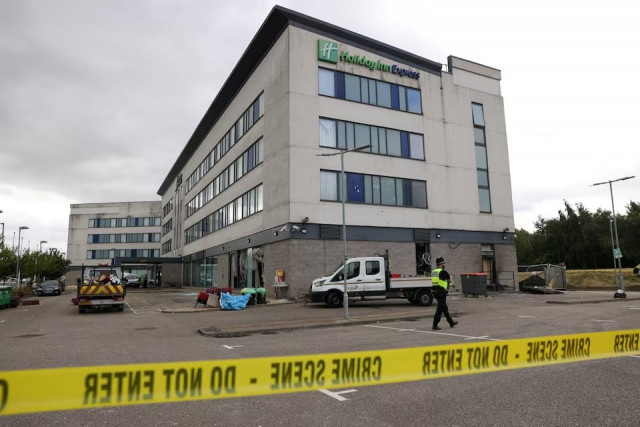 a police officer walks outside the holiday inn express hotel after rioters attacked the building in rotherham britain on august 5 2024 the government had said it was being used by asylum seekers photo reuters a police officer walks outside the holiday inn express hotel after rioters attacked the building in rotherham britain on august 5 2024 the government had said it was being used by asylum seekers photo reuters